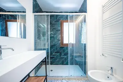 a bathroom with a glass shower and a sink at Aeterna RHome - Domus Piramide in Rome