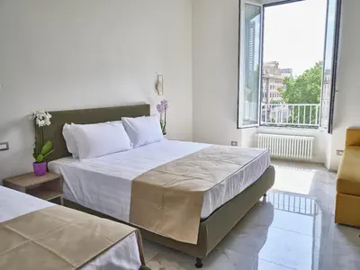 a bedroom with two beds and a large window at King Vittorio Guest House in Rome