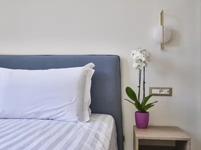 a bedroom with a blue bed with a plant on a table at King Vittorio Guest House in Rome