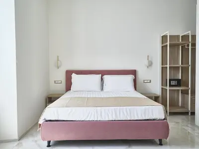 a bedroom with a large bed with white and purple at King Vittorio Guest House in Rome