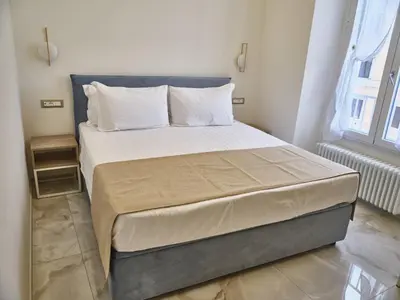 a bedroom with a large bed with white sheets and pillows at King Vittorio Guest House in Rome