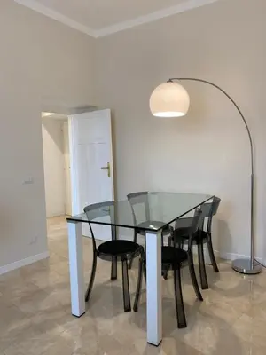 a glass table with black chairs and a lamp at Golden Round Palace in Rome