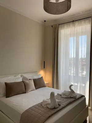 a white bedroom with a bed with towels on it at Golden Round Palace in Rome