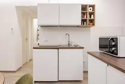 a white kitchen with a sink and a microwave at Urbanflat Termini in Rome