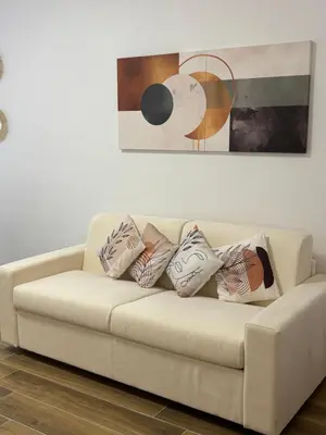 a white couch with pillows sitting under a painting at Domus Gregorio VII in Rome