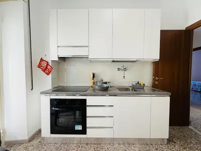 a kitchen with white cabinets and a sink at Metro A Battistini - Ramat House in Rome