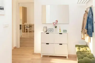 a living room with a white cabinet and a green couch at Urban Nest - Trastevere by RHR in Rome