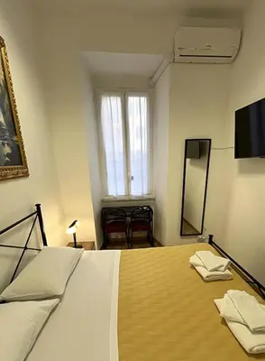 a bedroom with a bed and a mirror and a window at Vatican Artstudio in Rome