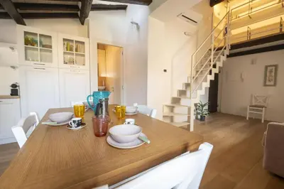 a kitchen and dining room with a wooden table at Roman Dream in Campo de Fiori in Rome