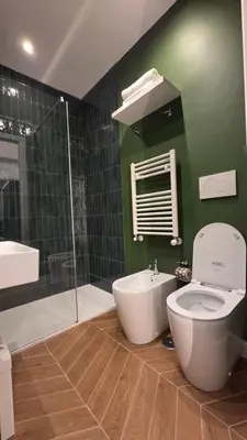 a green bathroom with a toilet and a shower at Luì & Giò Luxury Suite in Rome