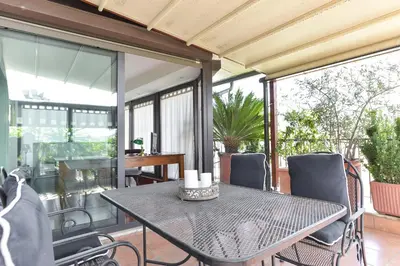 a table and chairs on a balcony with windows at Vatican Rome Suites in Rome