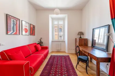 a living room with a red couch and a desk at Casa Medina, Charme in 5 min From Villa Borghese in Rome
