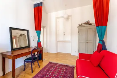 a living room with a red couch and a desk at Casa Medina, Charme in 5 min From Villa Borghese in Rome