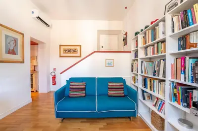 a blue couch in a room with bookshelves at Casa Medina, Charme in 5 min From Villa Borghese in Rome