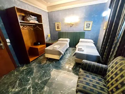 a room with three beds and a couch in it at Alloggio Positano in Rome