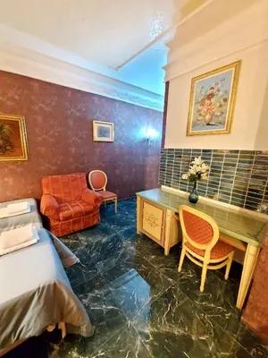 a room with a bed and a desk and a couch at Alloggio Positano in Rome
