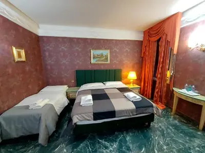 a hotel room with two beds in a room with at Alloggio Positano in Rome
