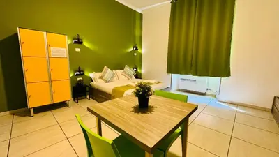a room with a bed and a table and a bed at Star City Guest House in Rome