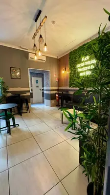 a lobby with a table and chairs and plants at Star City Guest House in Rome