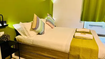 a bed in a room with a green wall at Star City Guest House in Rome