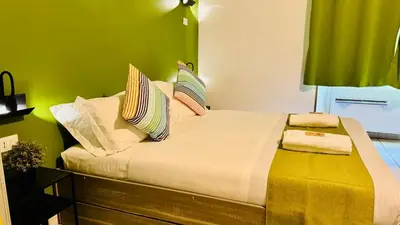 a bedroom with a large bed with green walls at Star City Guest House in Rome
