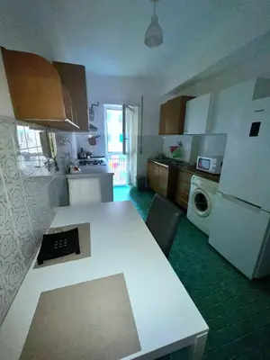 a kitchen with a white table and a white refrigerator at Montitiburtini Appartamento 510 Roma Centro in Rome