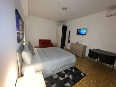 a bedroom with a bed and a desk and a television at Montitiburtini Appartamento 510 Roma Centro in Rome