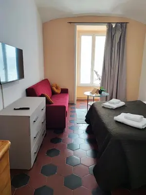 a room with two beds and a red couch at Residenza Giolitti in Rome