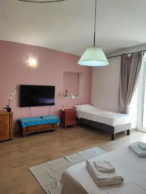 a bedroom with two beds and a flat screen tv at Residenza Giolitti in Rome