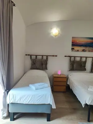 a bedroom with two beds and a lamp on a table at Residenza Giolitti in Rome