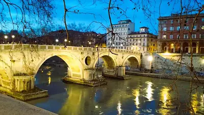 a bridge over a river in a city at night at MamaCri rifugio d'inverno a Roma in Rome