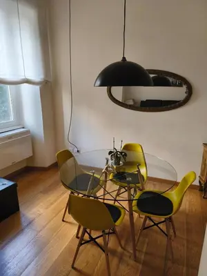 a dining room with a glass table and yellow chairs at Suite Tevere star in Rome