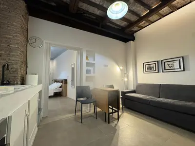 a kitchen and living room with a couch and a table at Cozy Corner in Magical Trastevere in Rome