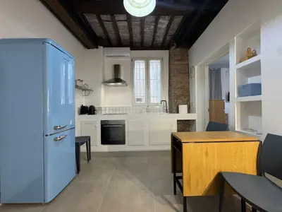 a kitchen with a blue refrigerator and a table at Cozy Corner in Magical Trastevere in Rome