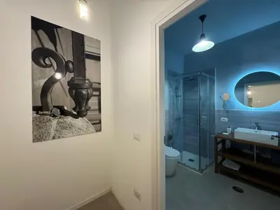 a bathroom with a sink and a painting on the wall at Cozy Corner in Magical Trastevere in Rome