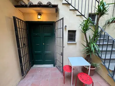 a green door with two red chairs and a table at Cozy Corner in Magical Trastevere in Rome