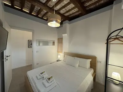a bedroom with a large white bed with two pillows at Cozy Corner in Magical Trastevere in Rome