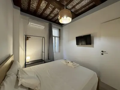 a bedroom with a white bed and a television at Cozy Corner in Magical Trastevere in Rome