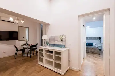 a living room with a table and a bedroom at The Best Rent - Modern one-bedroom apartment in the Porta Pia area in Rome