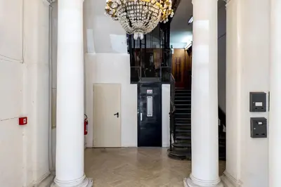 a hallway with white columns and a chandelier at The Best Rent - Modern one-bedroom apartment in the Porta Pia area in Rome