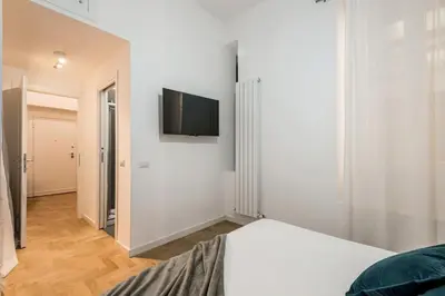 a bedroom with a bed and a flat screen tv on the wall at The Best Rent - Modern one-bedroom apartment in the Porta Pia area in Rome