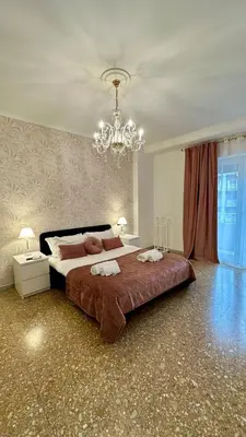 a large bedroom with a large bed and a chandelier at Vatican Museum YH in Rome