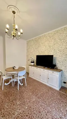 a dining room with a table and a television on a wall at Vatican Museum YH in Rome