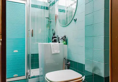a blue tiled bathroom with a toilet and a shower at Trastevere Urban Loft in Rome