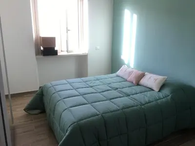a bedroom with a blue bed with two pillows on it at Francy's home sweet home in Rome