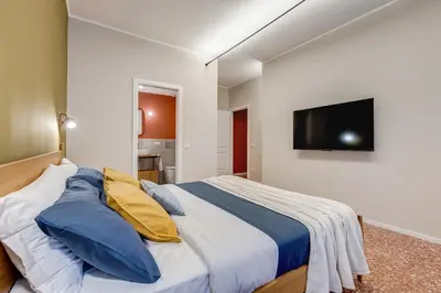 a bedroom with a bed with blue and yellow pillows at BDC - Trevi Premium 3BDR - 3BATH in Rome