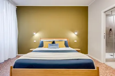 a bedroom with a large bed with blue and yellow pillows at BDC - Trevi Premium 3BDR - 3BATH in Rome