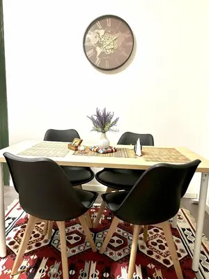 a dining room table with chairs and a clock on the wall at Caserina Lux Roma in Rome
