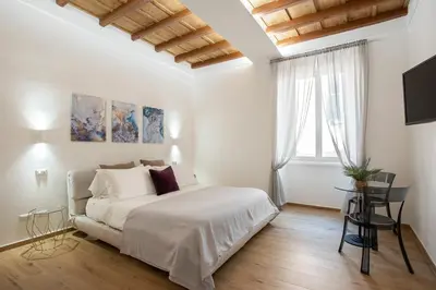 a white bedroom with a large bed and a window at Margherita Flat in Rome