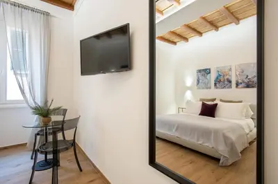 a mirror in a bedroom with a bed and a table at Margherita Flat in Rome